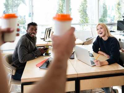 Smiling young colleagues sitting in office coworking