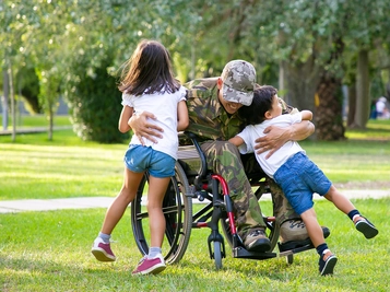 Happy Disabled Military Man in Wheelchair Returning Home