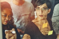 Manager Leading a Dynamic Standing Meeting with Team, Writing Notes in the Boardroom with Businesspeople, Colleagues, and Coworkers