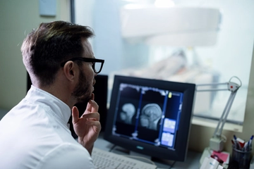 A doctor examining a patient's mri results on a computer screen at the hospital