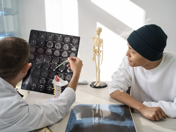 Cancer patient looks at MRI results with doctor's comments